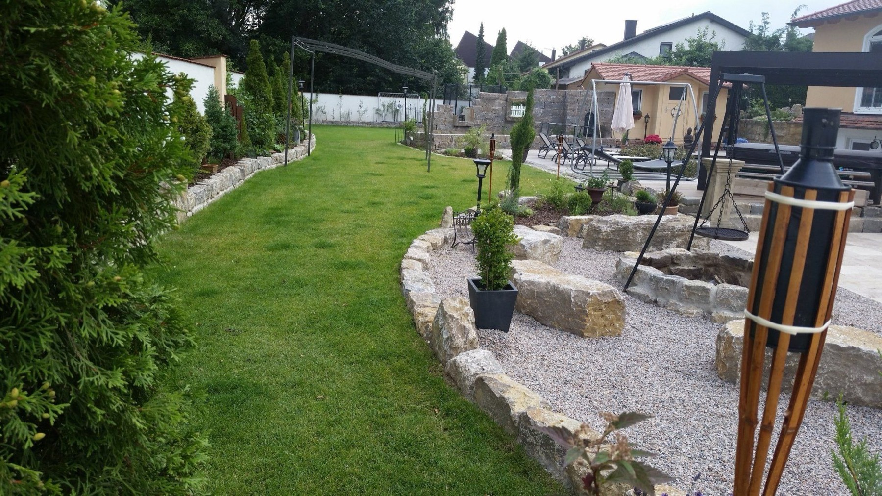 Gartenanlage mit Rasen und Natursteinterrasse von Renko Steinkunst